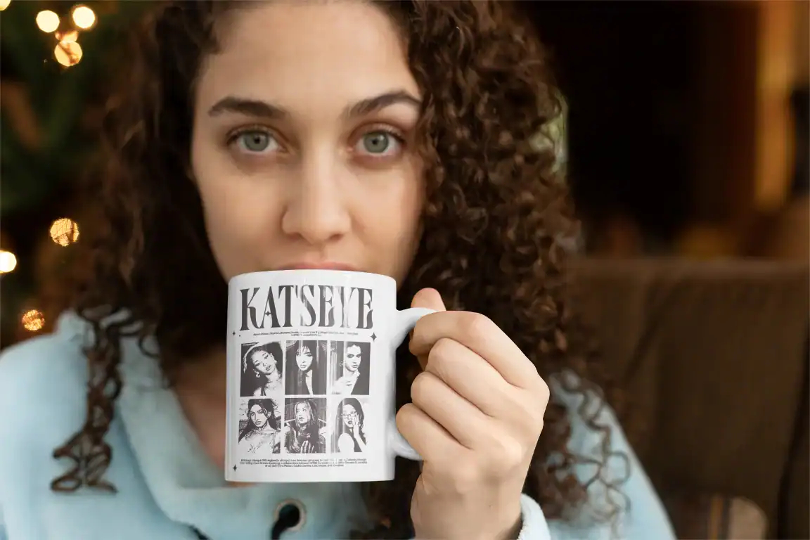 green eye girl sipping coffee from white ceramic katseye mug