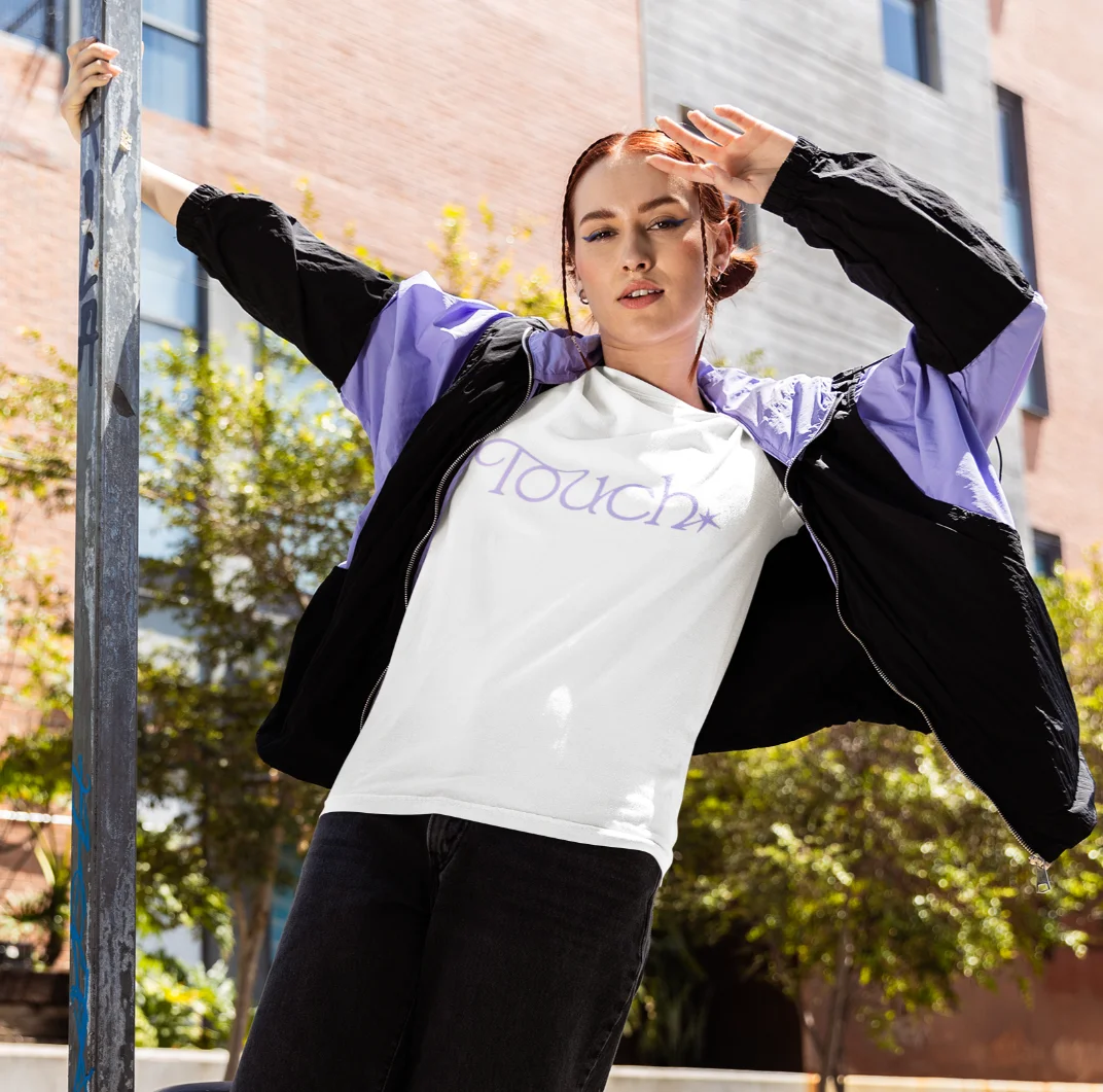 model posing wearing a white katseye 100% cotton t-shirt on the street