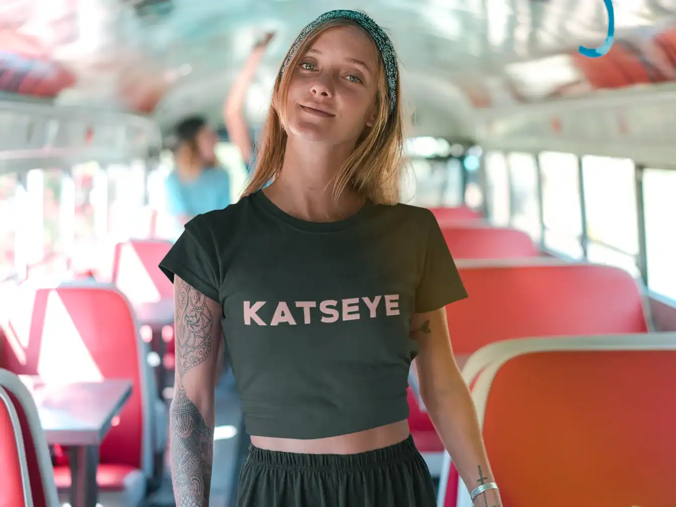 beautiful model wearing black katseye t-shirt while smiling on a bus
